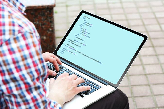 man on laptop programming code